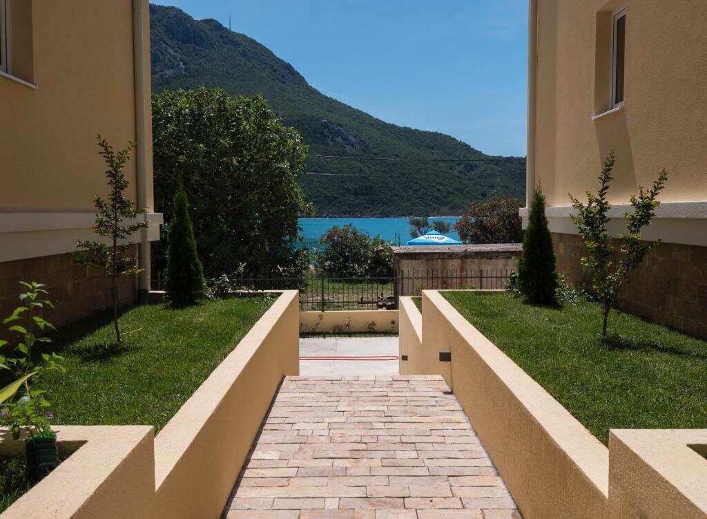 Garden path from the apartments down to Čanj beach with mountains behind